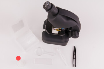 microscope on a white background with accessories for analyzes