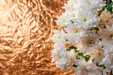 A bouquet of delicate white chrysanthemum flowers on a golden background.