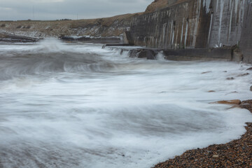 Waves crashing onto the sea wall at Colywell Bay, Seaton Sluice, Northumberland. Engalnd, UK.