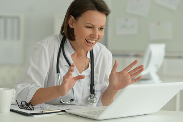 Portrait of smiling female doctor in hospital with laptop