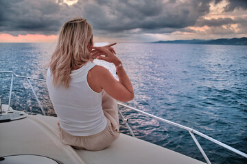 Beautiful young woman, blonde, relaxing on a luxury yacht against the backdrop of an amazing...