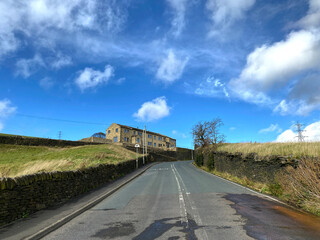 Fototapeta premium Looking up, Bradshaw Lane, with dry stone walls, fields and farms, on a sunny autumn day in, Bradshaw, Bradford, UK