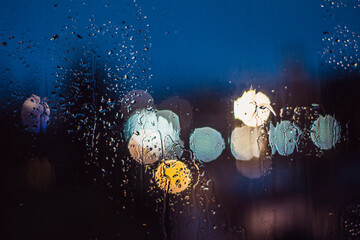 gotas de agua sobre un vidrio y fono de luces