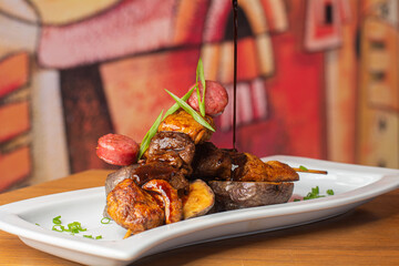 Anticucho comida típica del Perú, carne de res, pollo y chorizo con una guarnición de papas...