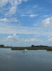 hombre remando en kayak laguna cielo despejado