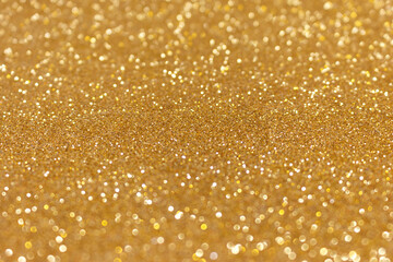 Golden glitter texture background. Shiny defocused festive backdrop.