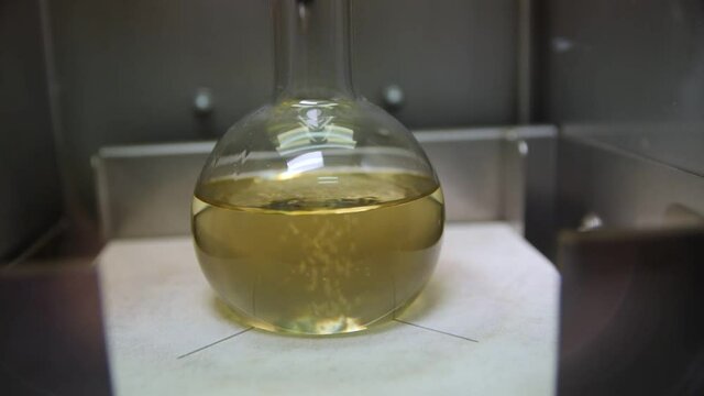 Boiling yellow liquid in flask of contemporary equipment