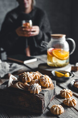 Woman is sitting with Hot tea with fresh grapefruit on wooden tablet. Healthy drink, Eco, vegan.