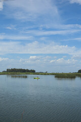 hombre remando en kayak laguna cielo despejado