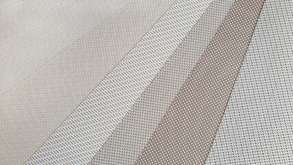 various warm beige tone color and texture of roman or roller blind samples in close up view. interior material selection.
