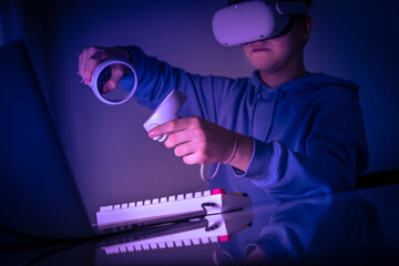 Teenager playing with virtual reality device. Cyberpunk futuristic mood, immersive experience with video game and VR 3D viewer technology. People using next-generation electronic devices. Tech concept