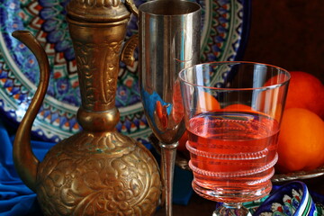 Oriental still life with red wine and oranges on wooden background