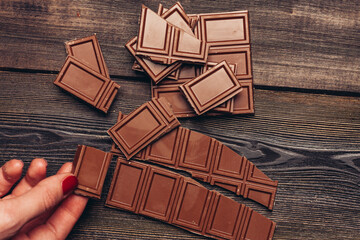 bar of chocolate broken into cubes on a wooden table