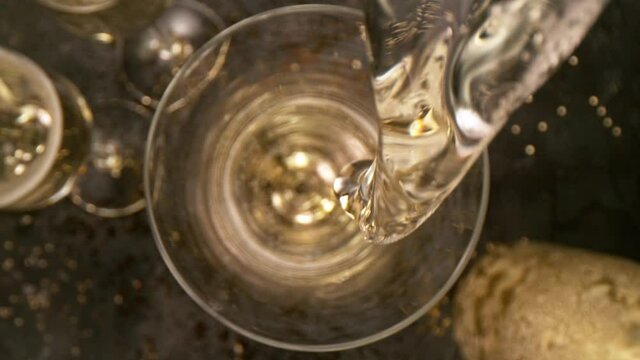 Camera Movement, Super Slow Motion Detail Shot of Pouring Champagne from Bottle on Black Stone Background at 1000fps.