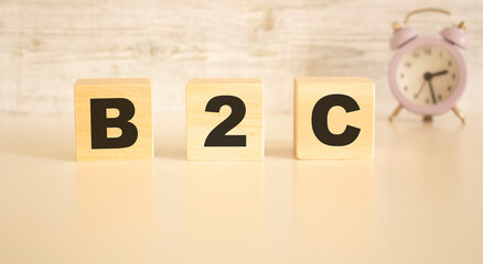 The word B2C consists of wooden cubes with letters, top view on a light background.