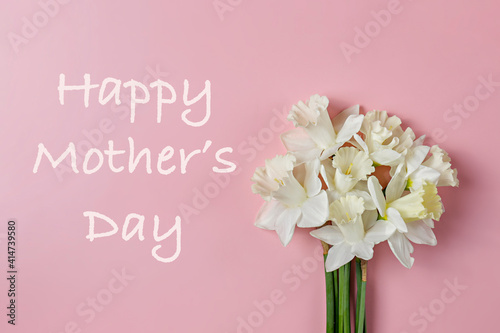 Happy mother's day greeting card template. Bouquet of white-yellow daffodils isolated on pink background. Tender minimalistic spring flowers composition. Top view, copy space, flat lay, close up.