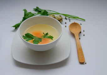 Diet chicken broth in a white bowl on a light background