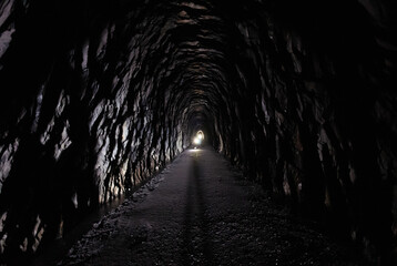 Looking through a 175 year old tunnel, with flashlights shining midway through