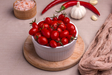 Fermented red cherry tomatoes in a white plate. Vegetarian food. Salted tomatoes. Pickled organic tomatoes. Homemade fermented foods. Food stocks.