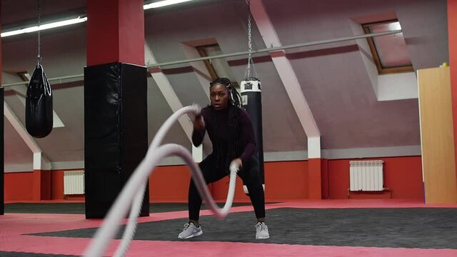 Sports training - a black woman training her hands using rope crossfit exercise