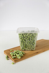 Peas on a light background in a frozen box, close-up