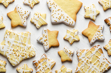 Star iced cookies with golden pearls, on a white backdrop. 