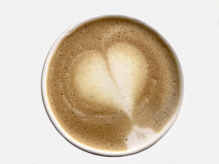 Top view of hot cappuccino coffee with heart shaped foam isolated on white background.  Top view, close-up, flat lay.