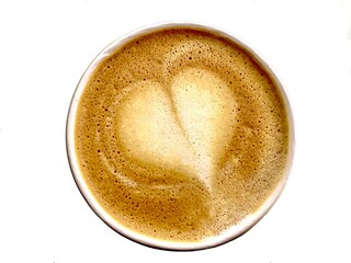 Top view of hot cappuccino coffee with heart shaped foam isolated on white background.  Top view, close-up, flat lay.