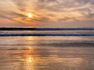 Obraz premium Colorful orange ocean beach sunset with deep clouded sky. Beautiful cloud over the sea during sunset. 