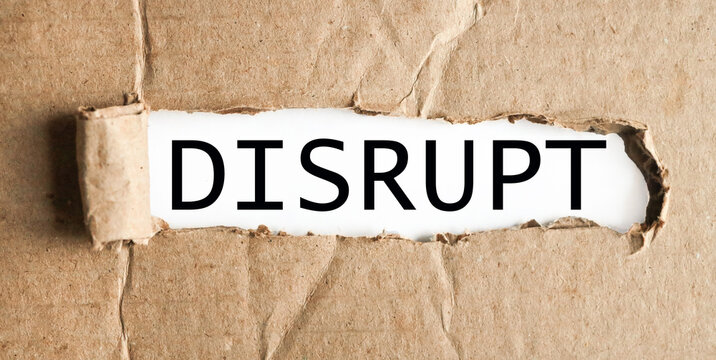 Disrupt. text on white paper over torn paper background.