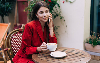 Thoughtful young lady calling on cellphone in cafe