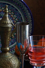 Fototapeta na wymiar Oriental still life with red wine and oranges on wooden background