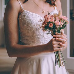 Elegant bride is getting ready in a hotel room, wearing vintage wedding. Wedding hotography concept.