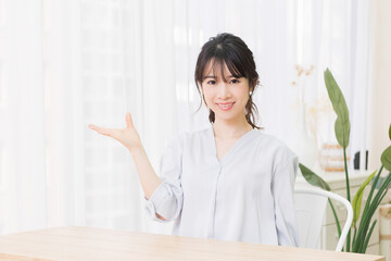 案内のジェスチャーをする若い女性