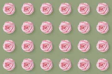 Flowers from a crumpled napkin form a repeating pattern on a dark pistachio background.Top view. Minimal design concept