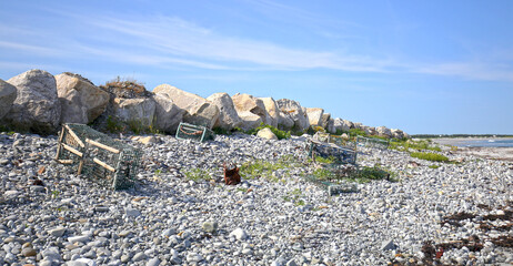 Old abandoned broken lobster traps Littering a gravel beach at Nova Scotia, East coast of Canada. 