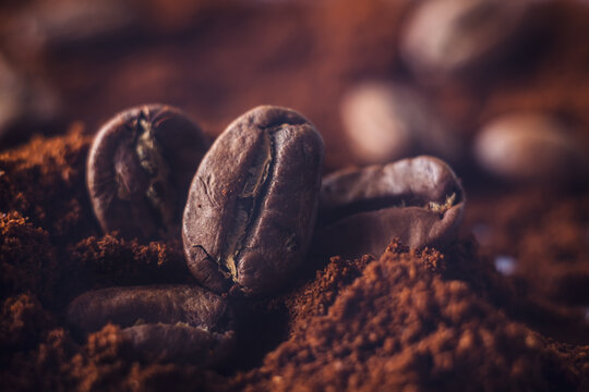 Ground coffee and grains macro shot. Smoke from freshly roasted coffee beans. © Josu