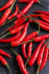 Red chili pepper isolated on black background, top view.