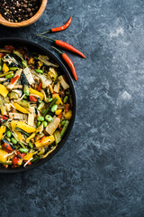 Fresh asian vegetables mix, Thai wok in a black pan on the black background with copy space. Healthy food