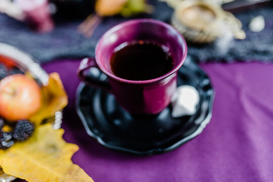 Soft Focus Purple Teacup On Jewel Tone Table For Halloween Decor