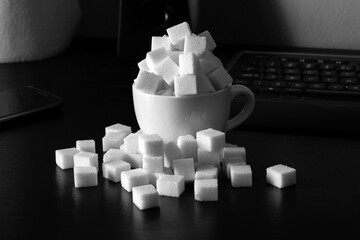 cup full of sugar cubes on a table