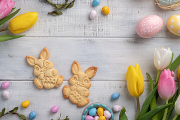 Happy easter background with bunnies, eggs, candies flowers