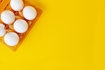 White egg on the yellow background. Design, visual art, minimalism place for inscription in plastic packaging