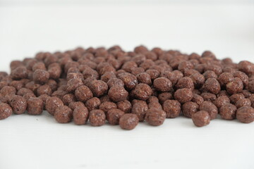 Chocolate corn balls scattered on a white background. Copy, empty space for text