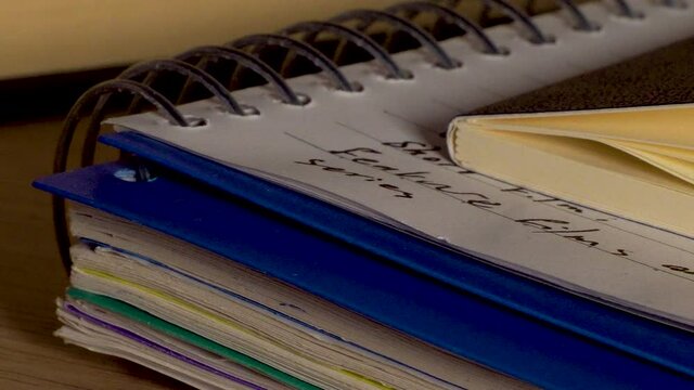 Close-up of notebooks arranged in stack on a desk