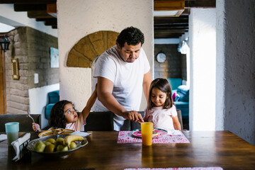 Fototapeta premium hispanic father having breakfast with his mexican daughters in dining room at home in mexico city