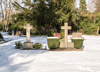 zwei Grabkreuze von der Rückseite mitten im Schnee