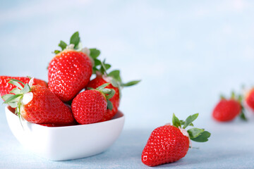 Raw Red Organic Strawberries in a Bunch on blue background.