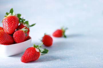 Raw Red Organic Strawberries in a Bunch on blue background.