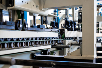 A industrial commercial envelope making machine, making paper envelopes for international distribution. Automated engineering machinery for mass production of paper envelopes.